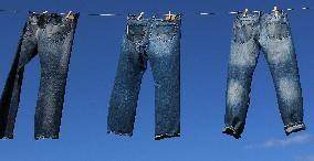 Jeans (blue)  hanging on a rope, clothes pins pegs