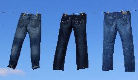 Jeans (blue)  hanging on a rope, clothes pins pegs