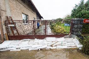 River Novohradka, village Luze, heavy rain, raised water level, house, bags with sand