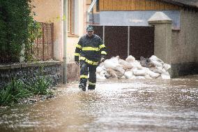 River Novohradka, village Luze, heavy rain, raised water level, fireman, bags with sand