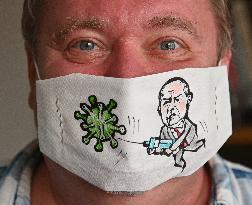 Czech cartoonist Lubomir Vanek decorates the protective face masks with cartoons, face mask