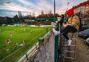 Bohemians fans with a ladder behind the fence