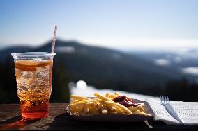 mountains, French fries, ketchup, Aperol, plastic cup, cutlery, food