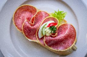 open sandwich, plate, salami, vegetable.
