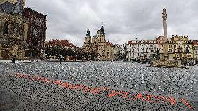 Sprayed orange words For incapable government's victims Old Town Square, Prague