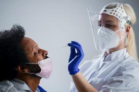 Nurse Making PCR Covid-19 Test For Black Man, White Background