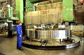 A worker processes pressure vessel equipment at a workshop of La