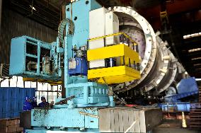 A worker processes pressure vessel equipment at a workshop of La