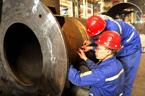 A worker processes pressure vessel equipment at a workshop of La