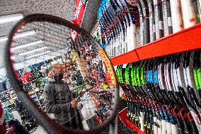 Shop with outdoor and sport equipment, sales manager, face mask