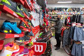 Shop with outdoor and sport equipment, sales manager, face mask