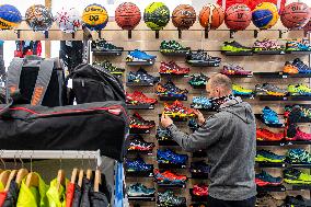 Shop with outdoor and sport equipment, sales manager, face mask
