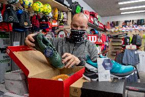 Shop with outdoor and sport equipment, sales manager, face mask