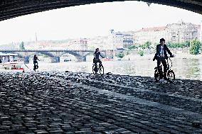 electric bike, electric powered bicycle, e-bike, cyclist, man, suit, woman, Vltava river, cyclists