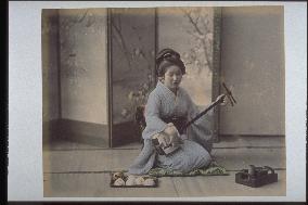 A woman playing the shamisen