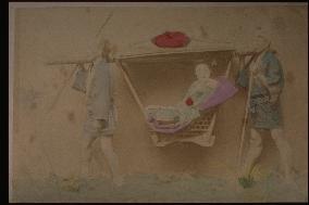A woman in a basket palanquin