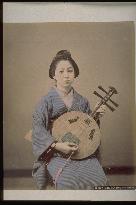 A woman playing the gekkin (a stringed instrament of Chinese origin)