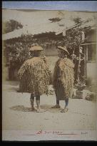 Men wearing mino,a straw raincoat