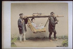 A woman in a basket palanquin