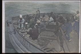 Chinese people at the bow of a steel ship