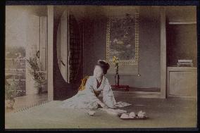 A woman enjoying tea at a tokonoma