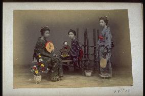 Girls holding dolls and fans