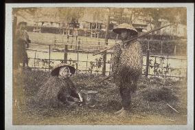 Farmers wearing straw raincoats and caps