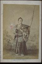 A samurai wearing hakama trousers and holding a bow