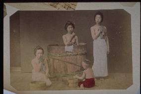 Women taking a bath in a wooden tub