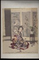 A woman in formal dress holding a bonsai