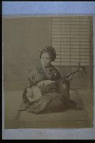 A woman playing the shamisen