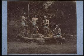Men drawing water from a well
