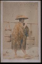 A farmer in a straw raincoat,with a straw cap on