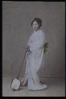 A woman holding a shamisen