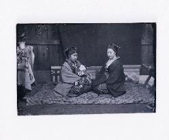 Two Women Sitting with One holding a Doll (Glass Negative in a Wooden Box)
