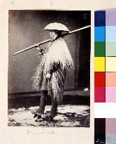 Man wearing mino,a straw raincoat