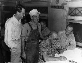 DIRECTOR JOHN FORD (SITTING IN SHORT SLEEVED SHIRT) NEXT TO