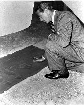 Gary Cooper making handprints in wet cement outside Sid Grau