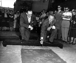 Van Johnson putting a date to his hand and footprints in wet