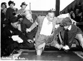 Al Jolson making knee-prints in the concrete outside Sid Gra