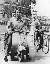 STEVE REEVES AND LIANA ORFEI  RIDING A VESPA SCOOTER BY THE