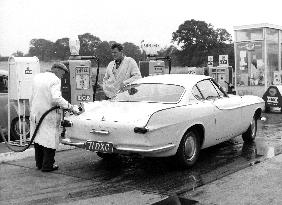 ROGER MOORE STAR OF THE SAINT WATCHING A GARAGE ATTENDANT FI