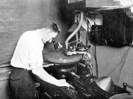 A Vitaphone technician examines the grooves on a disc being