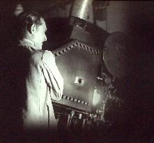 PROJECTIONIST standing by a Ross film projector 1930s / 40s