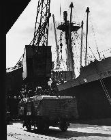 Unloading cargo from a large steamship in Manchester Docks