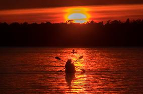 Kayakers Enjoy The Sunset On Cameron Lake - Canada