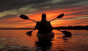 Kayakers Enjoy The Sunset On Cameron Lake - Canada