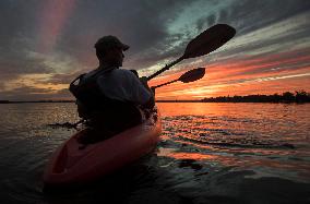 Kayakers Enjoy The Sunset On Cameron Lake - Canada