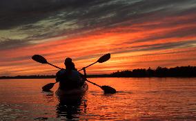 Kayakers Enjoy The Sunset On Cameron Lake - Canada