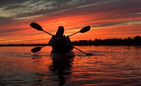 Kayakers Enjoy The Sunset On Cameron Lake - Canada